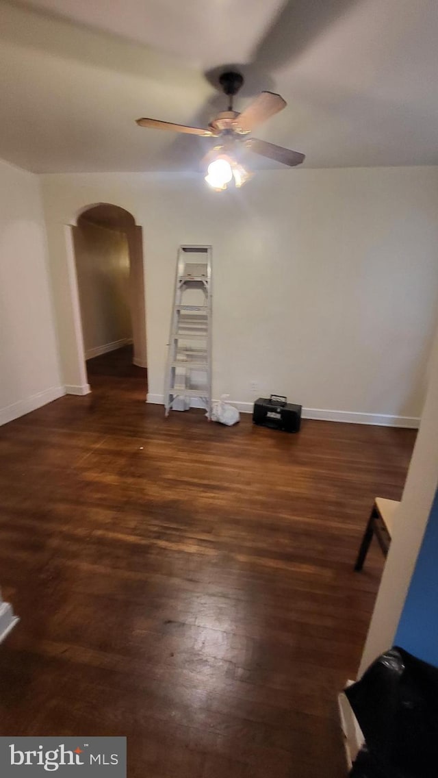 empty room featuring dark wood-type flooring and ceiling fan