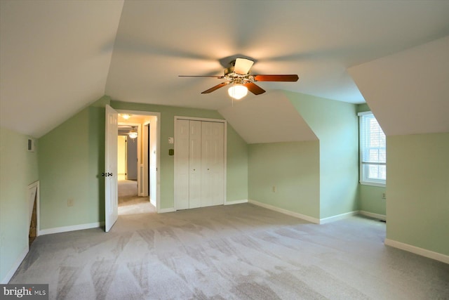 additional living space with vaulted ceiling, light colored carpet, and ceiling fan