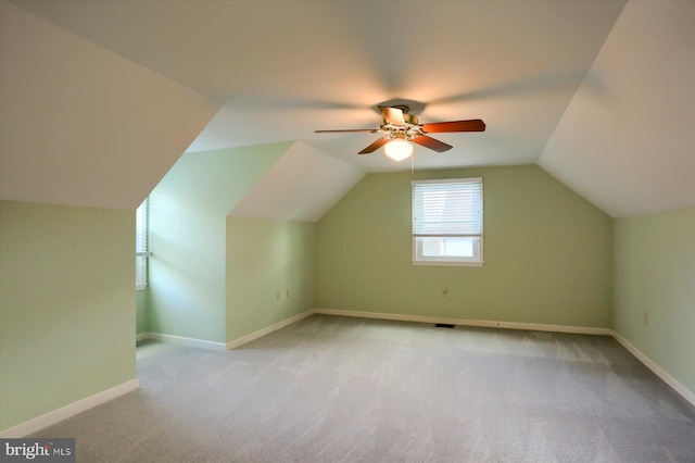 additional living space featuring ceiling fan, vaulted ceiling, and light carpet