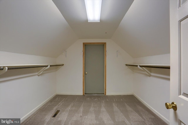 spacious closet with lofted ceiling and carpet