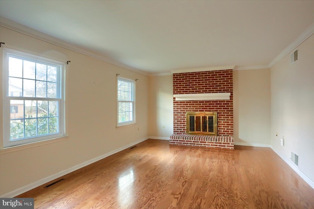 unfurnished living room featuring crown molding, a fireplace, and light hardwood / wood-style flooring