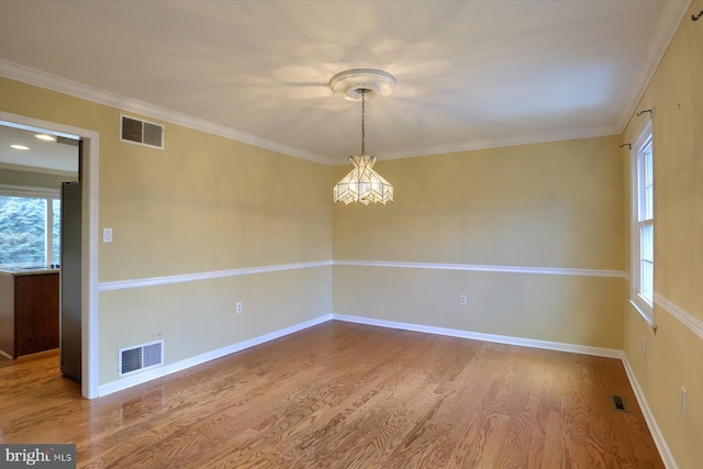 empty room featuring hardwood / wood-style floors and ornamental molding