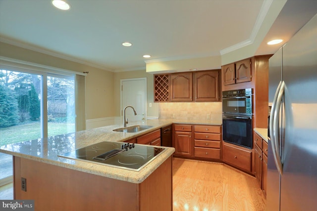 kitchen with sink, crown molding, light hardwood / wood-style flooring, kitchen peninsula, and black appliances