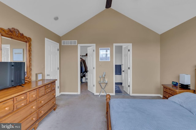 carpeted bedroom featuring a spacious closet, high vaulted ceiling, and a closet