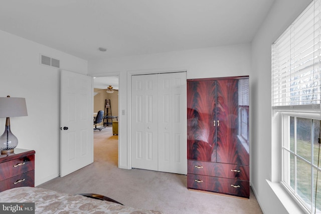 bedroom with light colored carpet and a closet