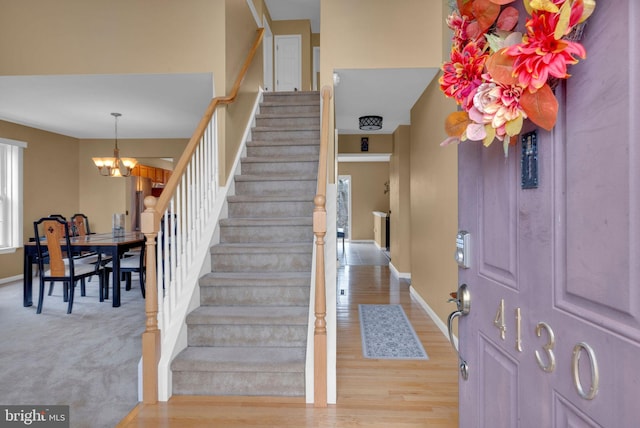 foyer entrance with a chandelier and light hardwood / wood-style floors