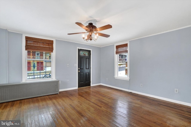 spare room featuring ceiling fan, crown molding, radiator heating unit, and wood-type flooring