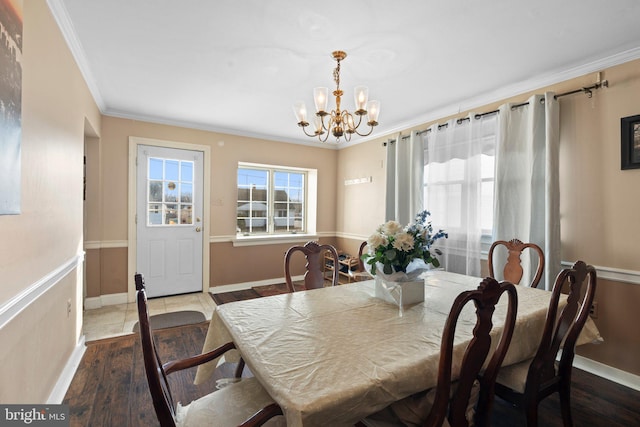 dining space with light hardwood / wood-style flooring, ornamental molding, and a chandelier