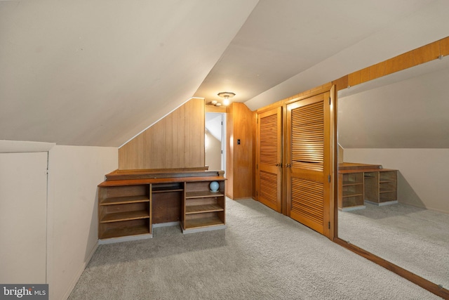 additional living space featuring lofted ceiling and light carpet