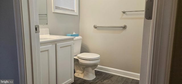 bathroom featuring vanity, toilet, wood finished floors, and baseboards