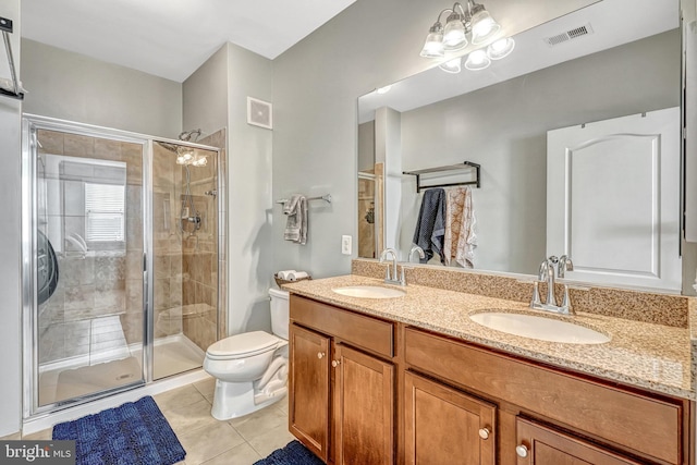 bathroom featuring vanity, toilet, a shower with shower door, and tile patterned flooring