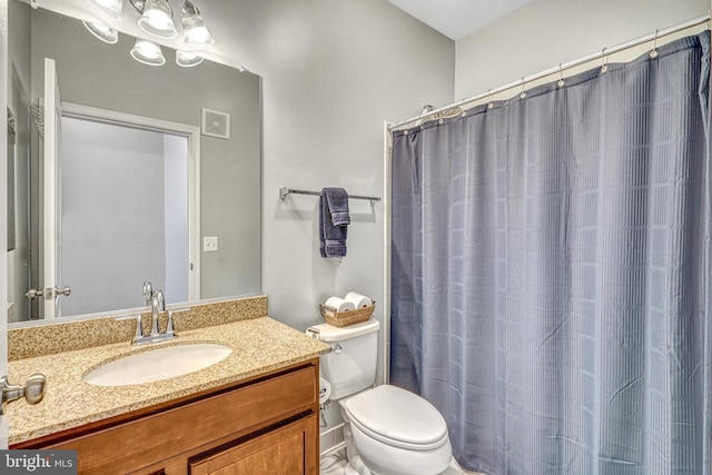 bathroom with walk in shower, vanity, and toilet