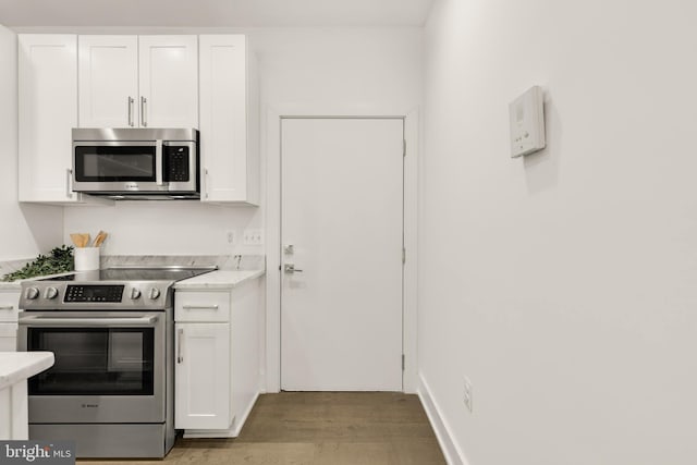 kitchen featuring white cabinetry, light hardwood / wood-style flooring, and appliances with stainless steel finishes