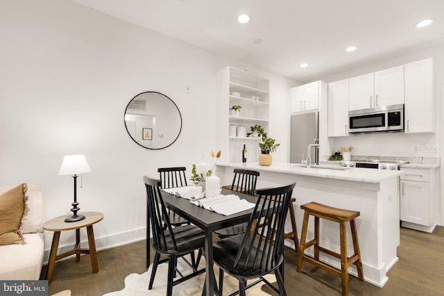 dining room with dark hardwood / wood-style flooring and sink