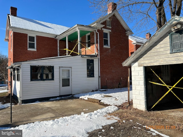 view of snow covered rear of property