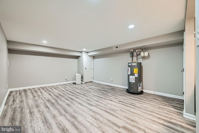 basement with water heater and light wood-type flooring