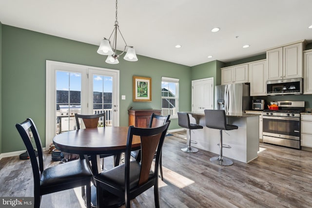 dining space featuring baseboards, wood finished floors, and recessed lighting