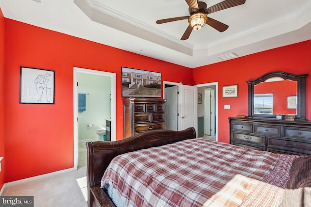 carpeted bedroom featuring connected bathroom, visible vents, baseboards, a raised ceiling, and crown molding