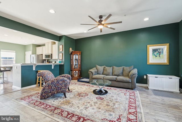 living room with ceiling fan, light wood finished floors, recessed lighting, and baseboards