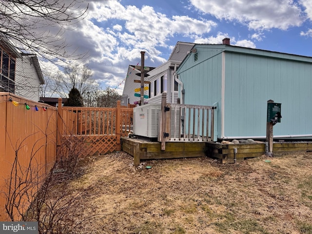 view of side of property with a deck and fence