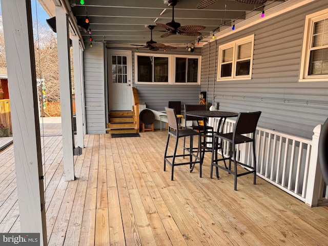 wooden deck featuring entry steps, outdoor dining area, and ceiling fan