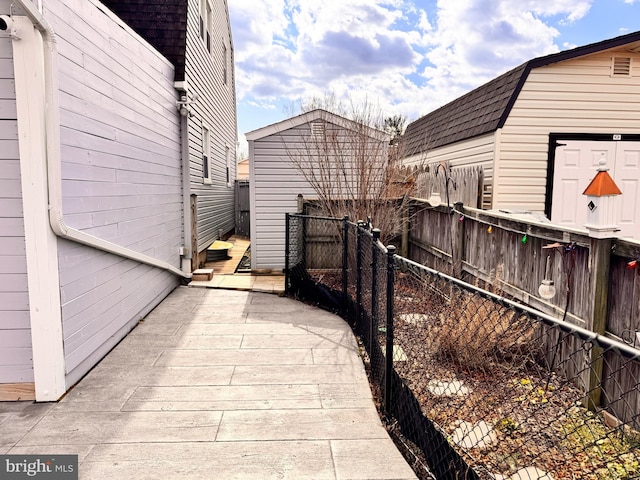 view of side of property with a storage shed, an outdoor structure, and fence