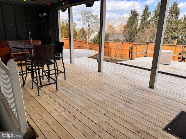 wooden terrace with outdoor dining space and a fenced backyard