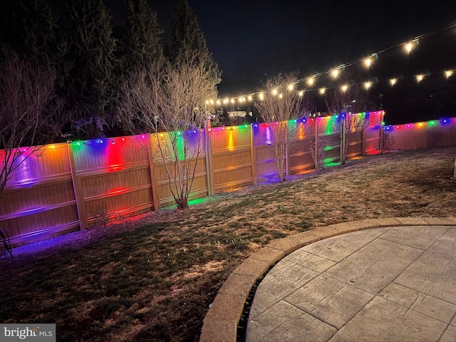 playground at twilight featuring a fenced backyard