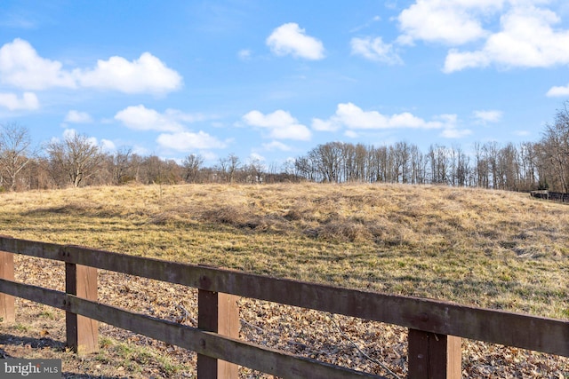 view of yard featuring a rural view and fence