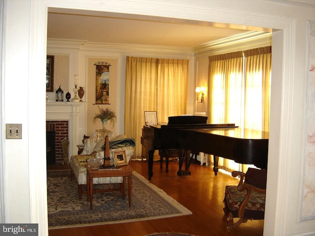 misc room with crown molding, a brick fireplace, and hardwood / wood-style flooring