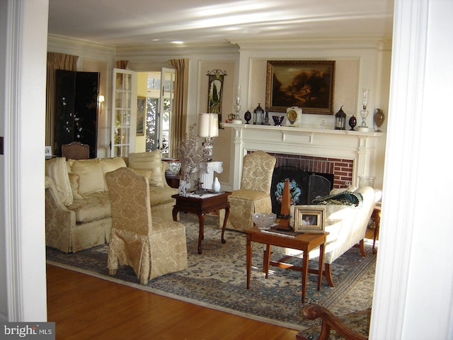 sitting room featuring ornamental molding, hardwood / wood-style floors, and a brick fireplace