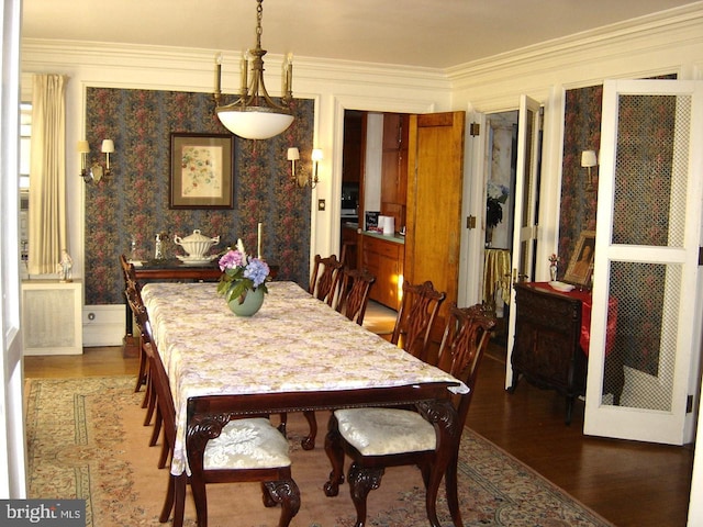 dining space featuring dark wood-type flooring, ornamental molding, and radiator