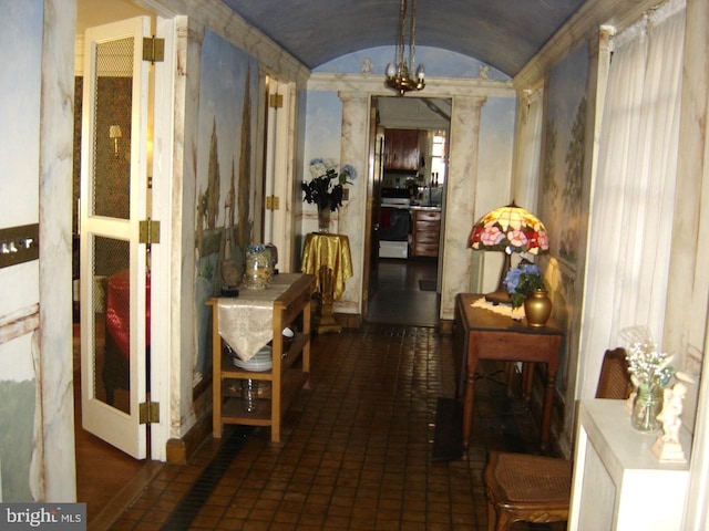 hallway with vaulted ceiling and a chandelier