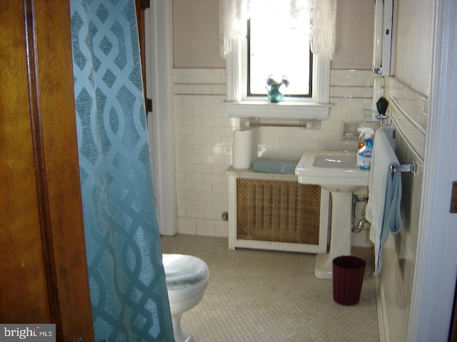 bathroom featuring tile walls, radiator, a shower with curtain, and toilet