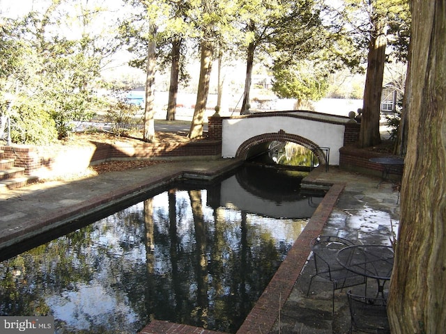 view of swimming pool with a patio and a water view