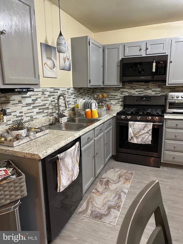 kitchen with range with gas cooktop, decorative light fixtures, tasteful backsplash, dishwasher, and sink