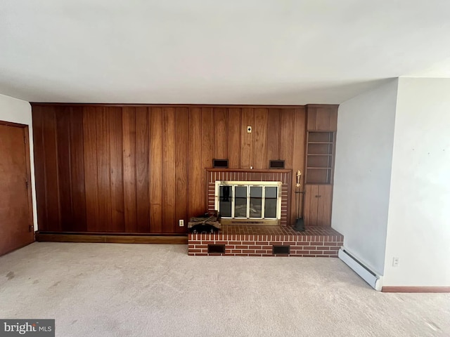 living room featuring wooden walls, a baseboard radiator, a fireplace, and light carpet