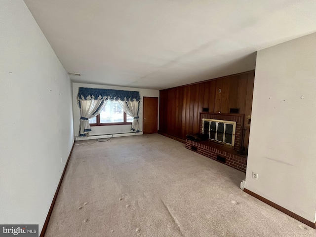 unfurnished living room with light carpet, a fireplace, and wood walls