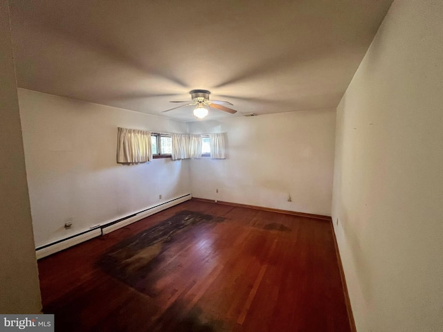 spare room featuring a baseboard heating unit, dark wood-type flooring, and ceiling fan