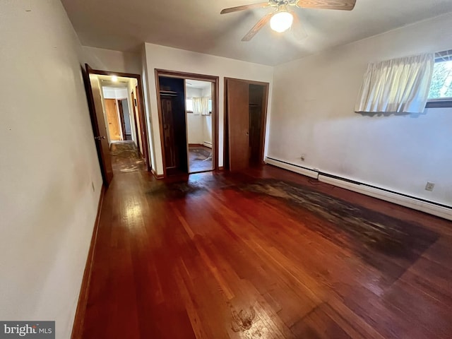 unfurnished bedroom with connected bathroom, dark wood-type flooring, ceiling fan, and baseboard heating