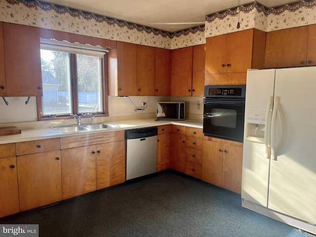 kitchen featuring white refrigerator with ice dispenser, sink, stainless steel dishwasher, and black oven