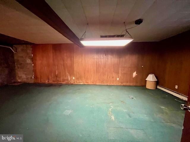 basement with baseboard heating and wood walls