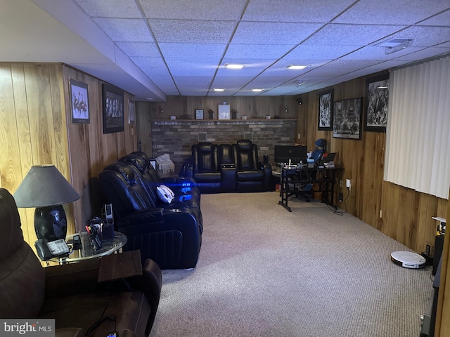 living room featuring carpet, a paneled ceiling, and wood walls