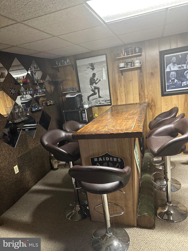 bar with carpet, a drop ceiling, and butcher block countertops