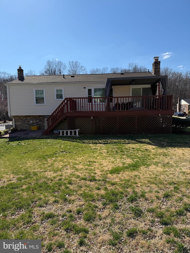 rear view of property featuring a lawn and a chimney