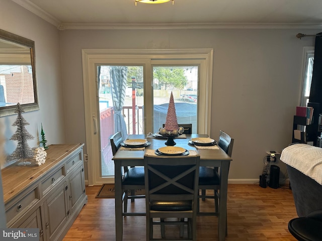 dining space with ornamental molding and light wood-type flooring