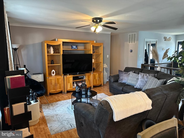 living room featuring crown molding, ceiling fan, and light hardwood / wood-style floors