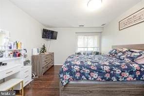 bedroom with dark hardwood / wood-style flooring