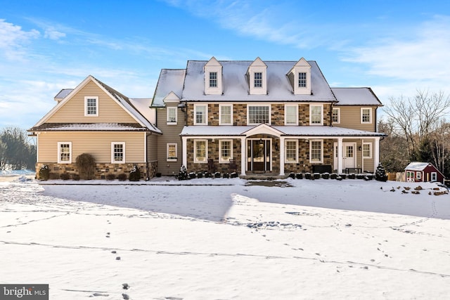 snow covered house featuring covered porch