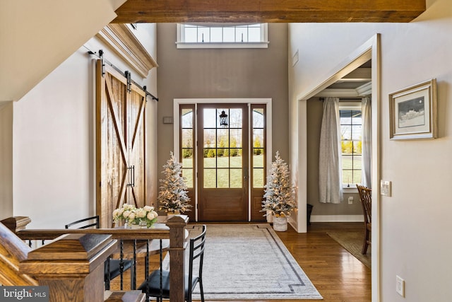 entryway with hardwood / wood-style floors, a wealth of natural light, and a barn door